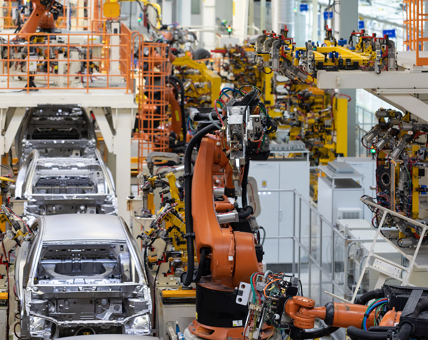 automatizacion-industrial-produccion-automotriz Línea de producción automatizada en la industria automotriz con robots ensamblando carrocerías de vehículos.